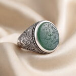 Green agate silver ring seen from an angle, showing the hand-chased floral band