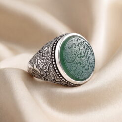 Green agate silver ring seen from an angle, showing the hand-chased floral band