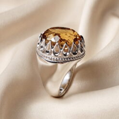 Natural yellow citrine cut as a large faceted oval, set in a handmade 925 sterling silver ring with an open teardrop gallery