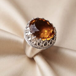 Top view of the faceted oval citrine showing the facets and the beaded silver rim of the setting